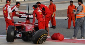 Ferrari mechanics look at the aftermath of Kimi Raikkonen's crash in the final day of the season's second testing session at Bahrain.