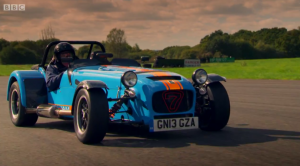 James drives the Caterham 620R with helmet and goggles.