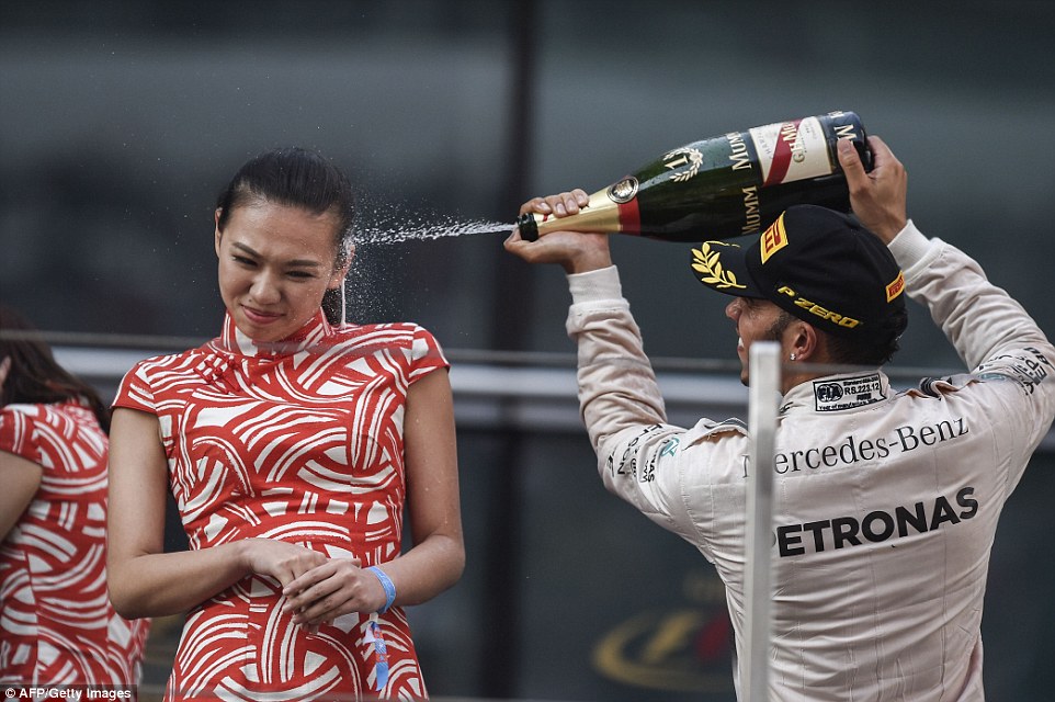 A bored Hamilton sprays an equally disinterested Chinese paddock babe with champagne.