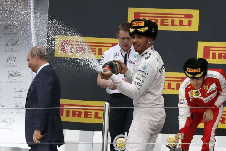 Hamilton celebrates by spraying champagne on Russian president Vladimir Putin.
